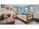 Cozy bedroom with natural light from two large windows, a twin-sized bed and comfortable seating area at 2013 Swede Gulch Rd, Evergreen, CO 80439