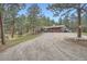 Exterior view of a house with a gravel driveway surrounded by pine trees at 2013 Swede Gulch Rd, Evergreen, CO 80439