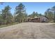Wide gravel driveway leading up to a house nestled in a pine forest at 2013 Swede Gulch Rd, Evergreen, CO 80439