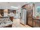 Spacious kitchen with modern appliances and wood cabinetry; island counter with marble countertop at 2013 Swede Gulch Rd, Evergreen, CO 80439