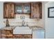 A well-designed kitchen area featuring a farmhouse sink, granite countertops, and dark wood cabinetry at 2013 Swede Gulch Rd, Evergreen, CO 80439