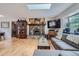 Open living area with hardwood floors, stone fireplace and a skylight above at 2013 Swede Gulch Rd, Evergreen, CO 80439