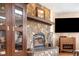 Living room featuring a stone fireplace, built-in display cabinet, and flat screen TV at 2013 Swede Gulch Rd, Evergreen, CO 80439