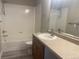 Bright bathroom features a shower-tub combo, sleek vanity, and neutral finishes at 9768 Mayfair St # E, Englewood, CO 80112