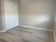 A minimalistic bedroom features white sliding door closet and light gray vinyl flooring at 9768 Mayfair St # E, Englewood, CO 80112