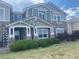 Charming two-story home with a stone facade, light green siding, manicured bushes, and a covered front porch at 9768 Mayfair St # E, Englewood, CO 80112