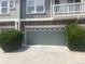 A well maintained garage with a stone facade and green door is accompanied by trimmed bushes at 9768 Mayfair St # E, Englewood, CO 80112