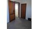 A view of a bedroom with neutral walls and plush carpet, wood door, and views of an adjacent room at 698 S 2Nd Ave, Brighton, CO 80601