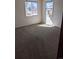A cozy bedroom featuring neutral walls, plush carpet, and ample natural light from two large windows at 698 S 2Nd Ave, Brighton, CO 80601
