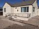 Charming single-story home featuring a cozy front porch with decorative metal railing and neutral stucco exterior at 698 S 2Nd Ave, Brighton, CO 80601