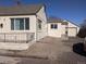A quaint home featuring a detached garage with gravel driveway, a fenced yard, and a neutral exterior at 698 S 2Nd Ave, Brighton, CO 80601
