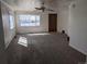 A bright living room featuring neutral walls and plush carpet with ample natural light from large windows at 698 S 2Nd Ave, Brighton, CO 80601