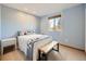 Light-blue bedroom with a double bed and a wood bench at 1490 S Iris St, Lakewood, CO 80232