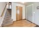 Bright entryway with staircase, coat closet, and light wood floors at 1490 S Iris St, Lakewood, CO 80232