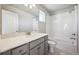 Bathroom featuring a single sink vanity, tiled floors, and shower-tub combo at 2283 Serenidad St, Brighton, CO 80601