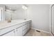 Bright bathroom with double sink vanity, white cabinets, large mirror, and glass enclosed shower at 2283 Serenidad St, Brighton, CO 80601