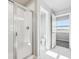 Well-lit bathroom with tiled shower, toilet, and mountain view at 2283 Serenidad St, Brighton, CO 80601