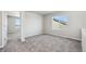 Bright bedroom with a neutral color palette, gray carpet, and large window offering natural light at 2283 Serenidad St, Brighton, CO 80601