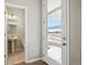 Bright entryway featuring a modern glass door and a view into the downstairs half-bathroom at 2283 Serenidad St, Brighton, CO 80601