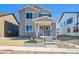 Charming two-story home with gray brick and siding, featuring a bright red front door at 2283 Serenidad St, Brighton, CO 80601