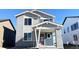 Two-story home with brick and siding, covered porch and a red front door at 2283 Serenidad St, Brighton, CO 80601