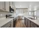 Well-equipped kitchen featuring stainless steel appliances, quartz countertops, and stylish wood flooring at 2283 Serenidad St, Brighton, CO 80601