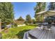 Green backyard oasis with a wooden fence, tall trees, a deck, a hammock and outdoor seating at 5327 Suffolk Cir, Castle Rock, CO 80104