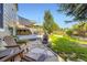 Expansive backyard featuring a deck with seating, a stone patio with a fire pit, and lush landscaping at 5327 Suffolk Cir, Castle Rock, CO 80104