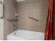 Tile shower over tub is equipped with safety grab bars and convenient storage shelves at 8258 S Sicily Ct, Aurora, CO 80016