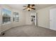 Carpeted room with bright windows, lighted ceiling fan, and views into the living area at 8258 S Sicily Ct, Aurora, CO 80016