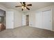 Carpeted bedroom features lighted ceiling fan and double closets at 8258 S Sicily Ct, Aurora, CO 80016