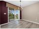 A dining room features sliding glass doors to the back porch and a chandelier above at 8258 S Sicily Ct, Aurora, CO 80016