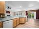 The kitchen features wood cabinets, a light countertop, and a view of the living room and the backyard at 8258 S Sicily Ct, Aurora, CO 80016