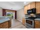 Kitchen features stainless steel appliances, wood cabinets, a tile backsplash, and a view to the backyard at 8258 S Sicily Ct, Aurora, CO 80016