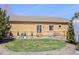 A well-maintained backyard with a small lawn, landscaping, patio, and access to the home at 418 Rifle Ct, Broomfield, CO 80020