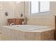 Bathroom with large tub and neutral tile surround at 418 Rifle Ct, Broomfield, CO 80020