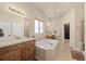 Bathroom featuring dual vanity, tub, walk-in shower, and walk-in closet at 418 Rifle Ct, Broomfield, CO 80020