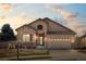 Charming single-story home featuring stucco siding, stone accents, manicured lawn, and a two-car attached garage at 418 Rifle Ct, Broomfield, CO 80020