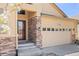 Welcoming front entrance enhanced by stone accents, a modern front door and a well maintained two car garage at 418 Rifle Ct, Broomfield, CO 80020