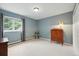 Serene bedroom featuring blue walls, a large window, and closet with doors at 18590 Lower Lake Rd, Monument, CO 80132