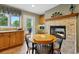 Cozy dining area featuring a fireplace, wood table and tiled floors, perfect for gatherings at 18590 Lower Lake Rd, Monument, CO 80132
