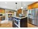 Kitchen with island, stainless steel appliances, breakfast nook, and brick fireplace at 18590 Lower Lake Rd, Monument, CO 80132