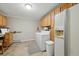 Laundry room featuring side by side washer and dryer, refrigerator, and light wood cabinets for storage at 18590 Lower Lake Rd, Monument, CO 80132