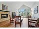 Bright living room with vaulted ceilings, large windows, fireplace, and access to a deck at 18590 Lower Lake Rd, Monument, CO 80132