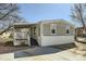 Charming manufactured home featuring a covered porch and driveway with mature trees, perfect for easy access at 2885 E Midway Blvd # 1542, Denver, CO 80234