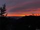 Picturesque sunset over mountain silhouette and city lights with a serene sky at 10390 Hondah Dr, Littleton, CO 80127