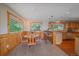 Charming dining area with wood-paneled walls, natural light, and adjacent kitchen access, blending rustic charm and functionality at 10390 Hondah Dr, Littleton, CO 80127