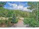 A view from above showcases the lush natural landscape, blue sky, and rock driveway of this attractive mountain home at 10390 Hondah Dr, Littleton, CO 80127