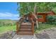 Inviting entryway showcasing wood stairs, a blue door, and natural stone accents at 10390 Hondah Dr, Littleton, CO 80127