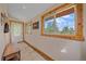 Bright foyer features tile floors, coat hooks, a storage bench, and natural light from a window at 10390 Hondah Dr, Littleton, CO 80127